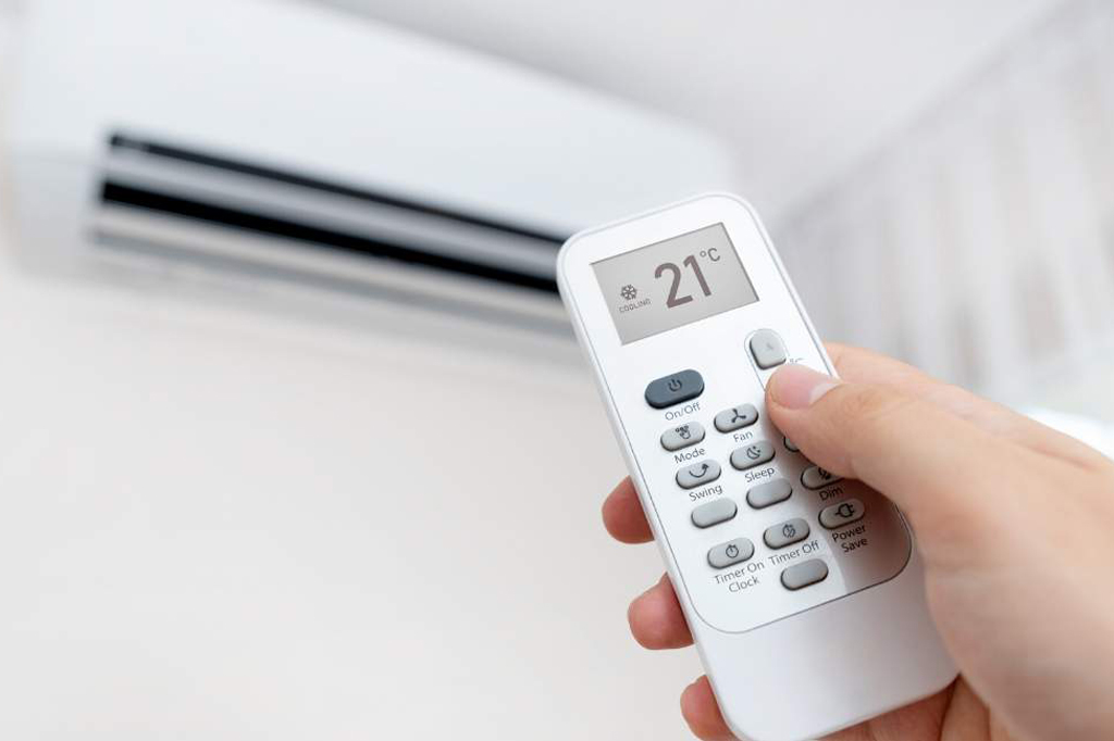 How should the air conditioner be set in hot weather?
